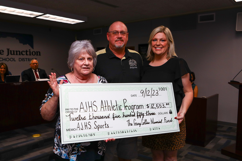 Joanne Collins and Aubrey Collins Jackson with AJHS Athletic Director Jason Hutchens, presenting donation to AJHS Athletic Program